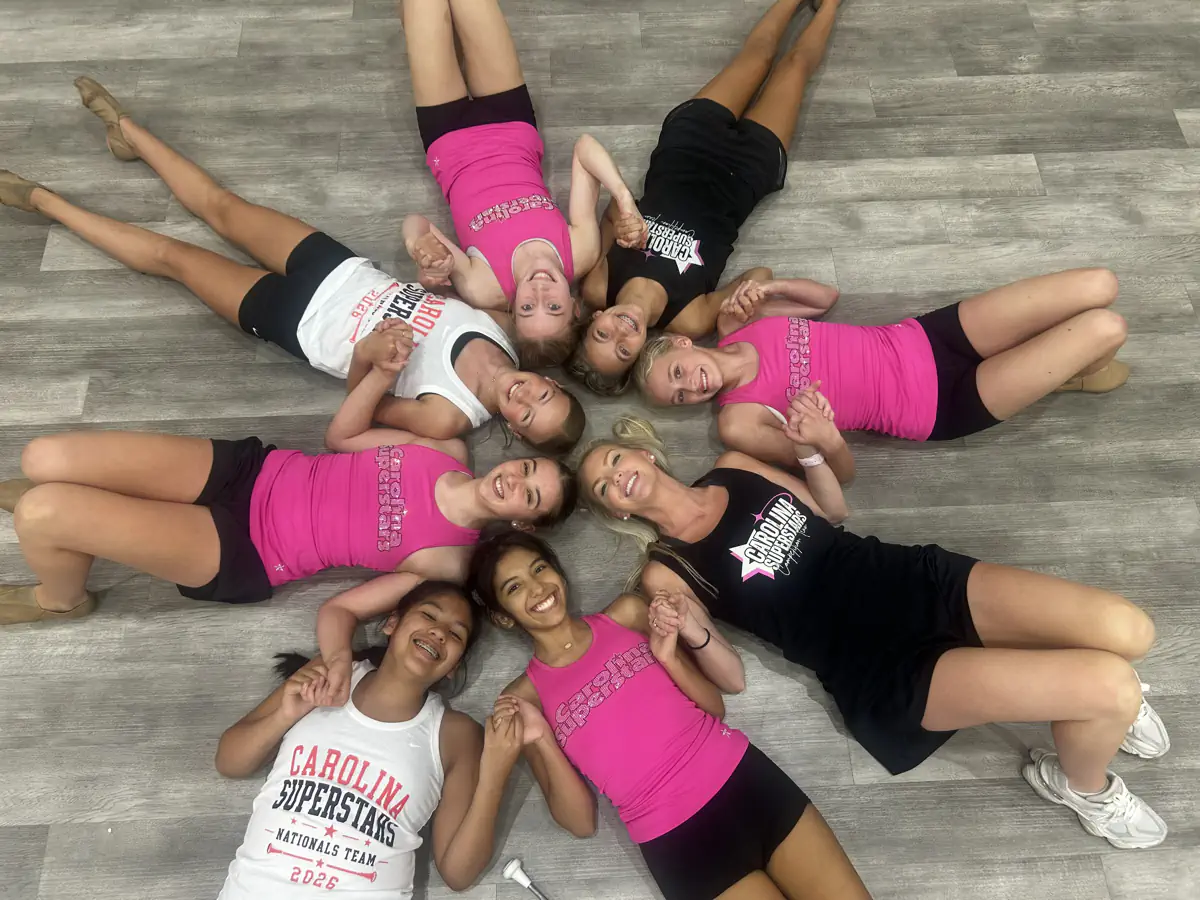 Carolina Superstars cheerleaders lying in circle on gym floor