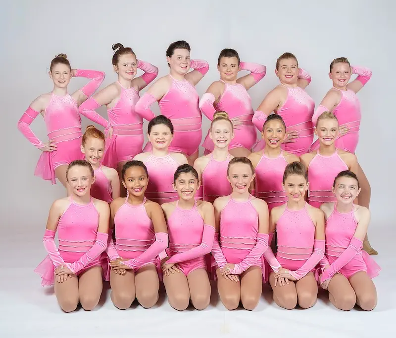 Young dance team posing in matching pink costumes