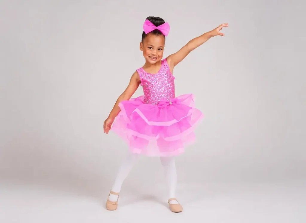 Young girl in pink sequin tutu ballet costume posing gracefully