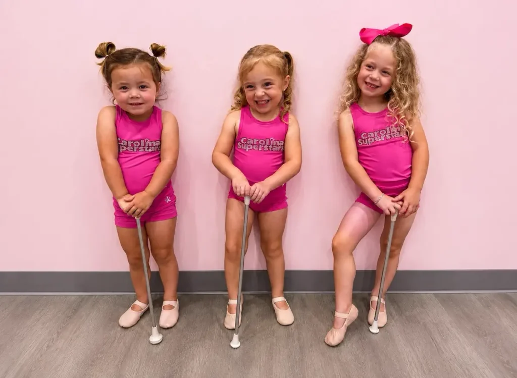 Three young girls in pink Carolina Superstars dance uniforms